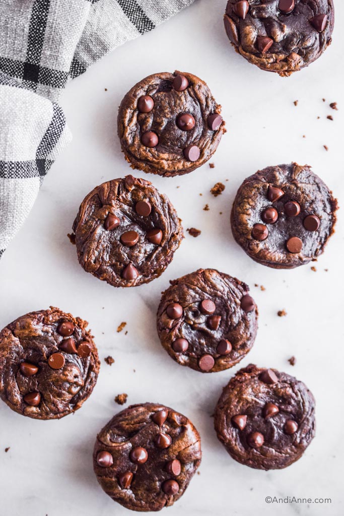 flourless banana chocolate muffins on a white background with plaid kitchen towel