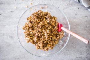 oat crumble mixture in glass bowl with spatula