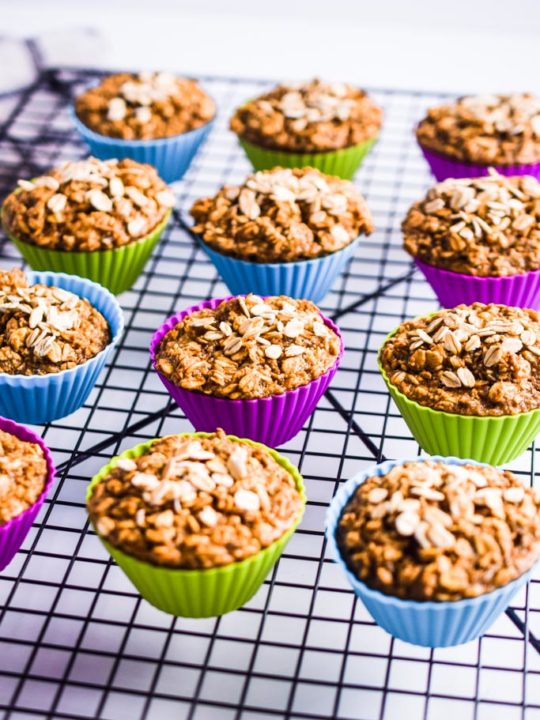 banana oatmeal muffins in colored silicone cups on a black cooling rack