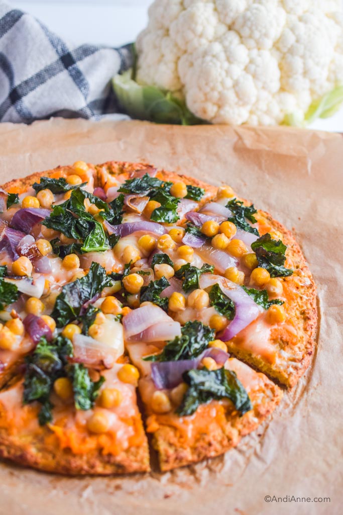 close up of cauliflower pizza with chickpeas, kale, onions and sweet potato puree.