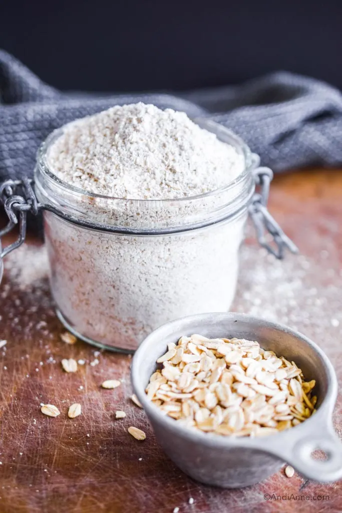 oat flour in a glass container with small cup of rolled oats in front
