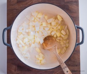 onions in dutch oven with wooden spoon