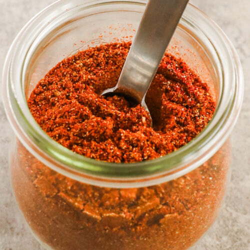A jar of taco seasoning with a spoon in it