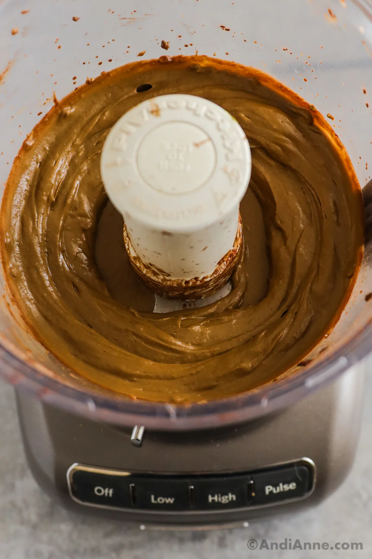 A food processor with smooth creamy chocolate avocado pudding inside.