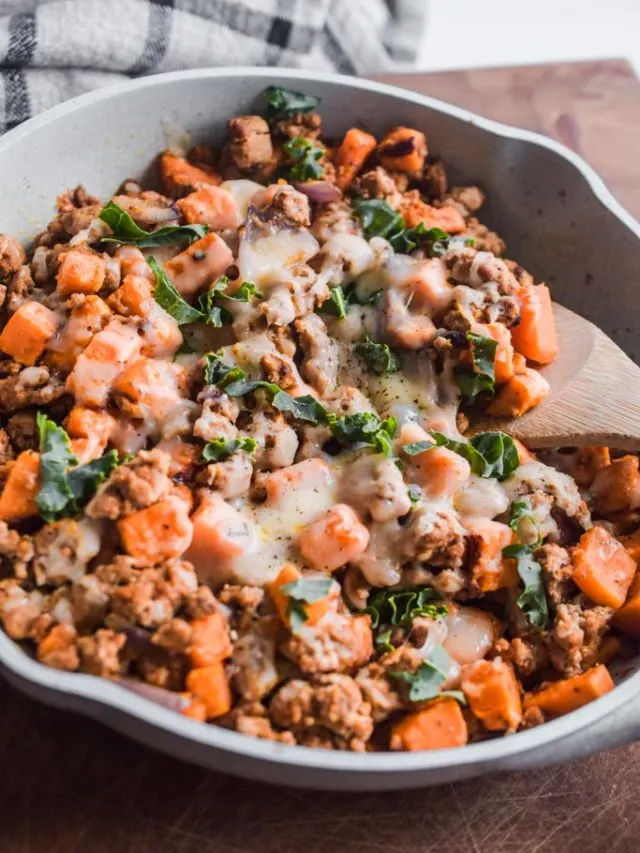 A frying pan with ground turkey, chopped sweet potato, and melted cheese. 
