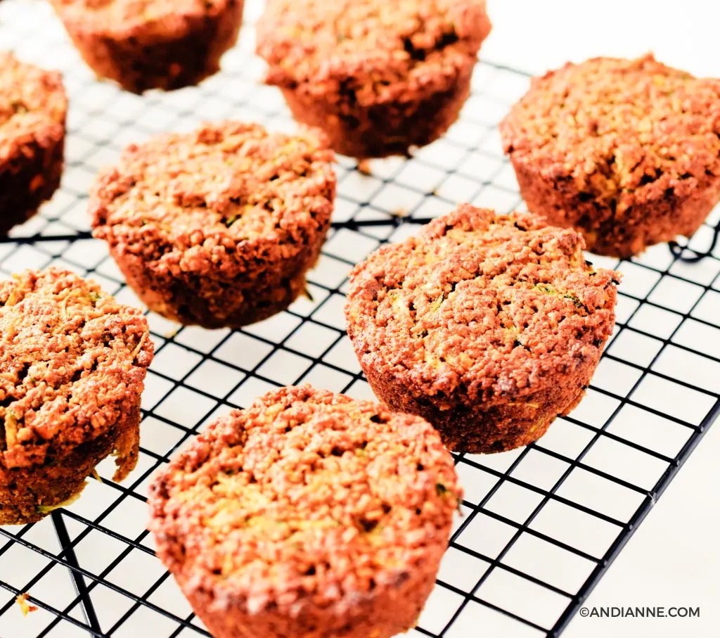 zucchini orange oat muffins on a black cooling rack.