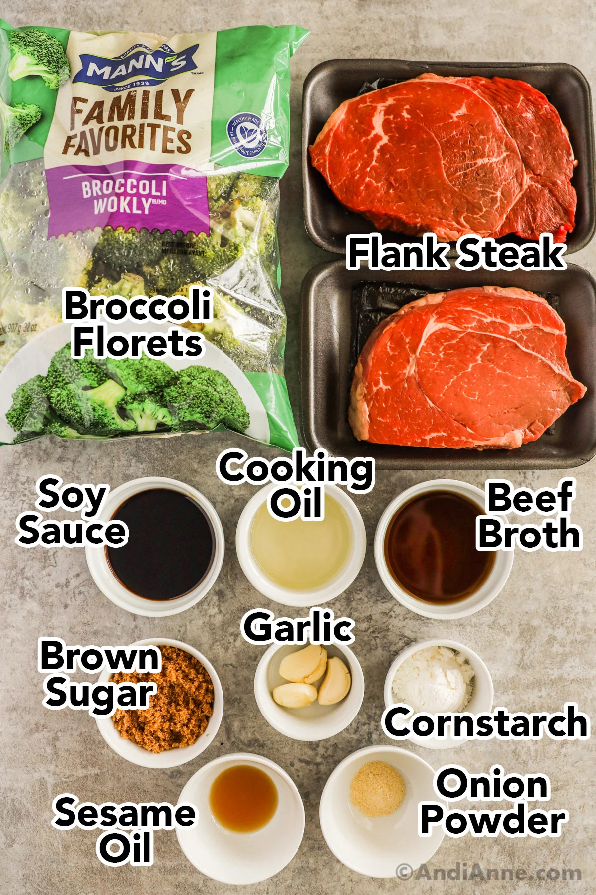Recipe ingredients including bag of broccoli florets, two raw flank steaks, and small bowls of soy sauce, cooking oil, beef broth, brown sugar, garlic, cornstarch, sesame oil and onion powder.