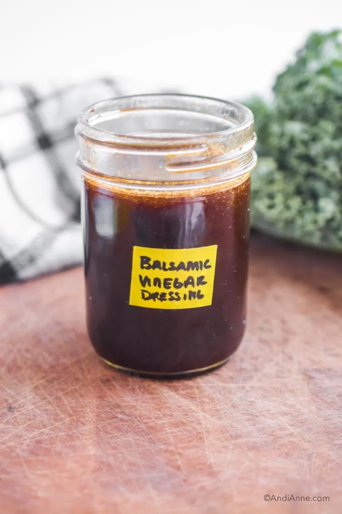 balsamic vinegar dressing in a mason jar with yellow label on front. 