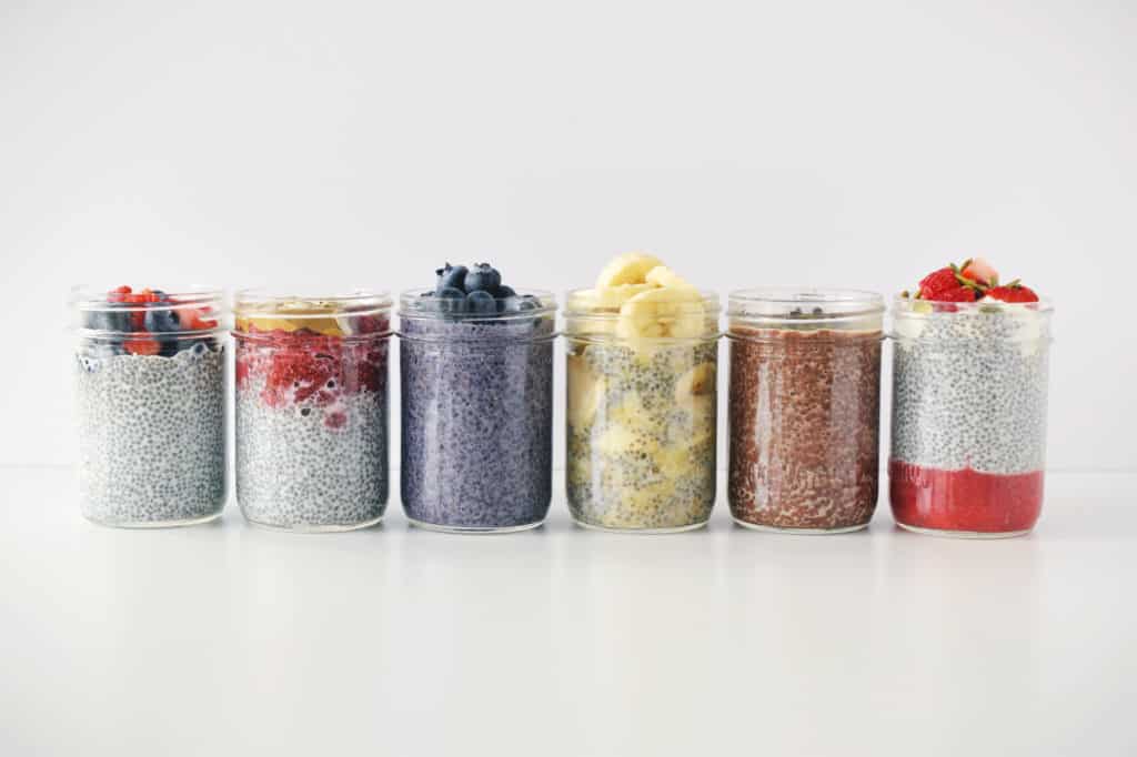 six chia pudding recipes in mason jars on white background side by side