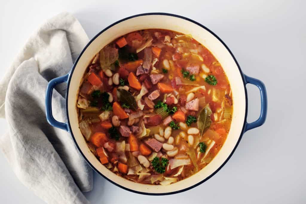 ham and bean soup in a white and blue large cast iron enamelled pot