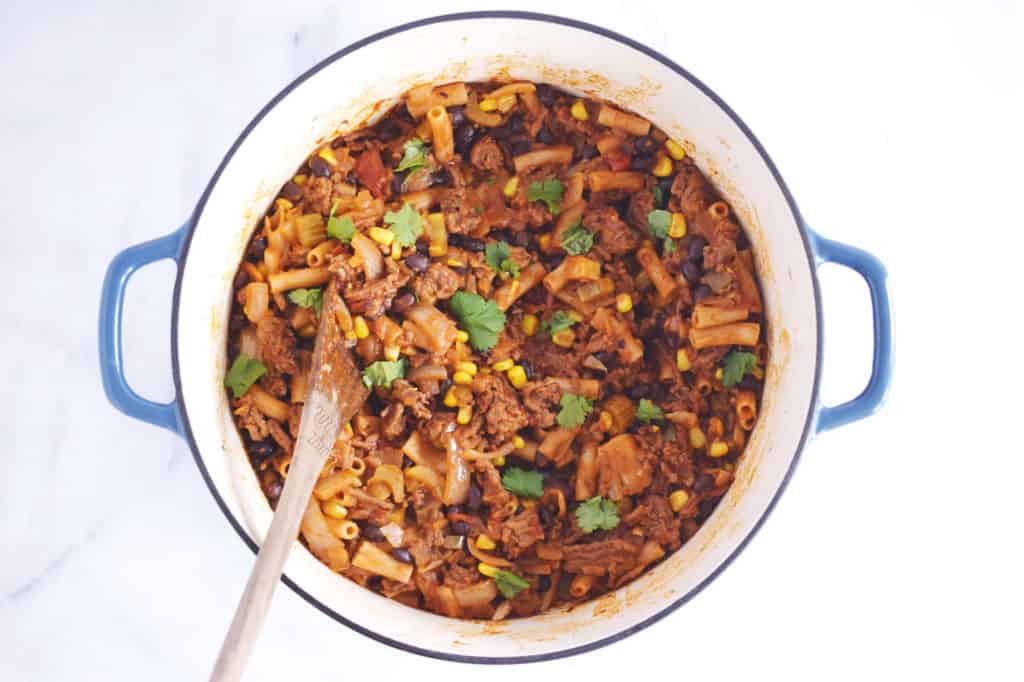 one pot taco pasta in blue cast iron enamelled pot with wooden spoon