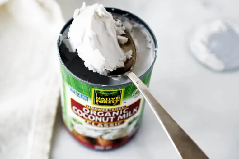 can of coconut milk with spoon scooping out the cream portion