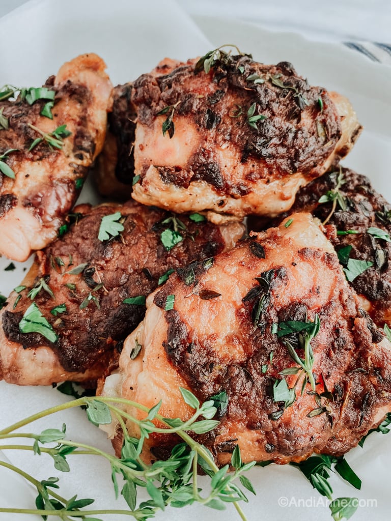 Dijon thyme baked chicken thighs in a white bowl with parchment paper