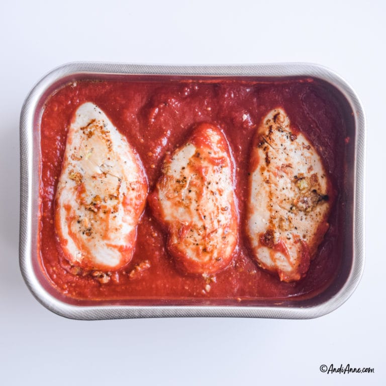 3 chicken breasts in tomato sauce in a steel casserole dish