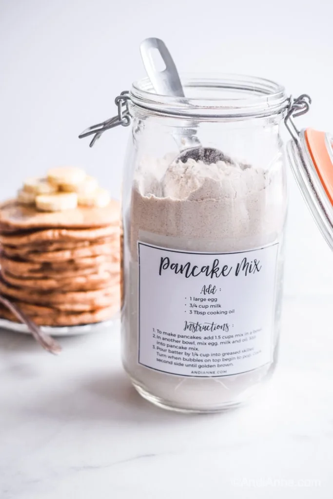 homemade pancake mix in a jar with pancakes stacked in background