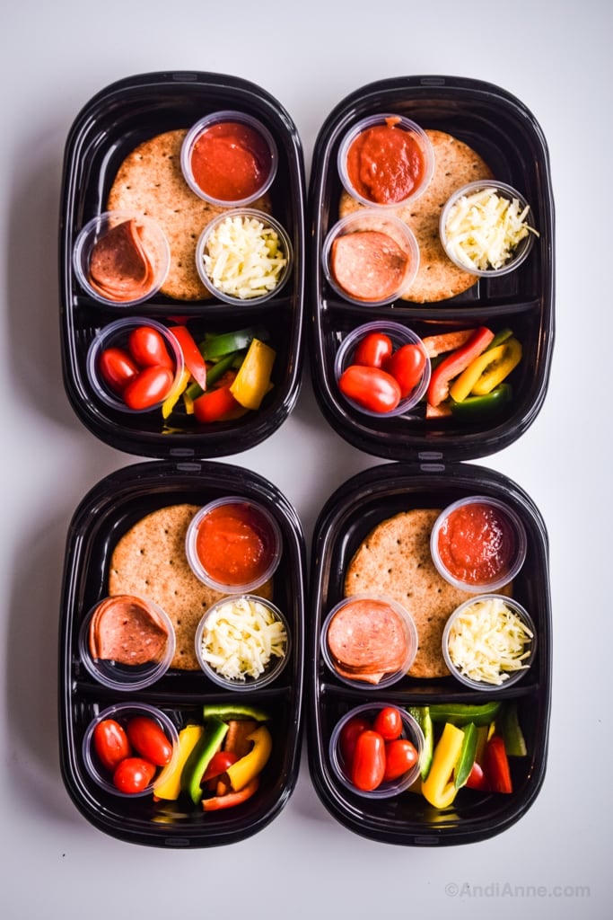 Homemade pizza lunchables stacked side by side in black containers