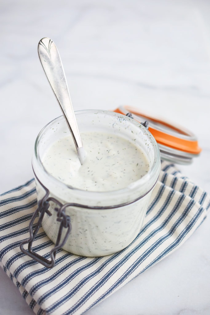 homemade buttermilk ranch dressing in canning jar with spoon and striped napkin