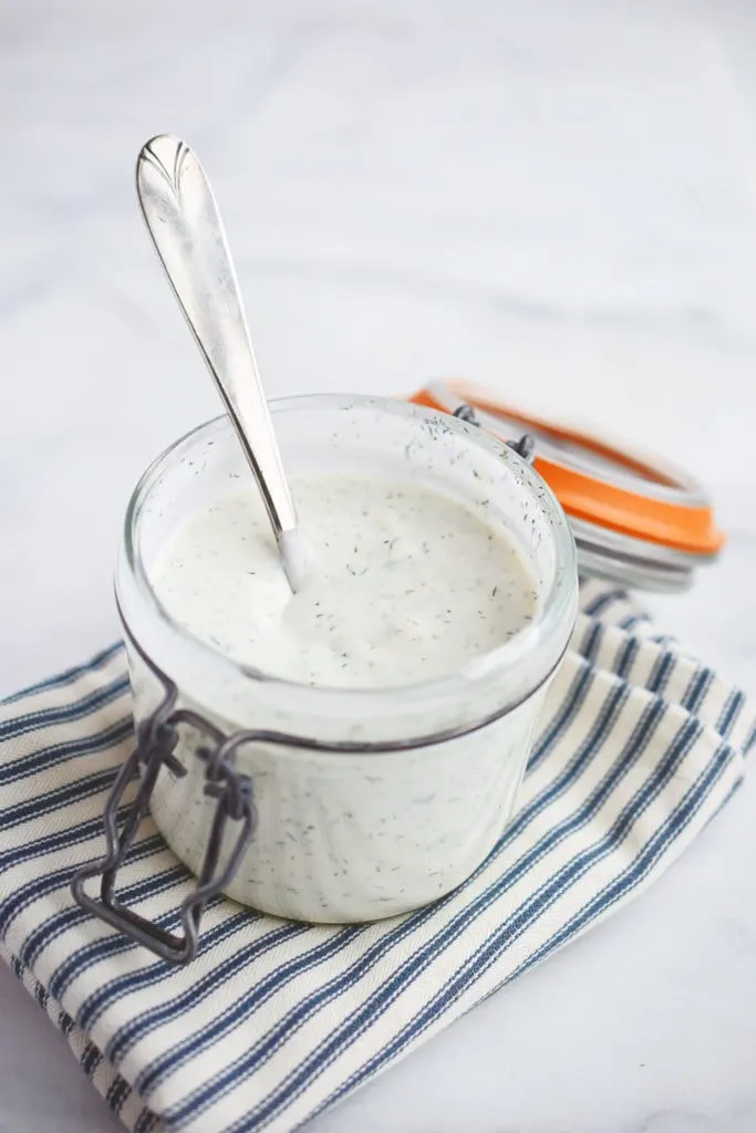 homemade buttermilk ranch dressing in canning jar with spoon and striped napkin