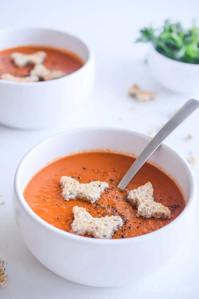 classic homemade tomato soup recipe with butterfly croutons in a bowl with a spoon
