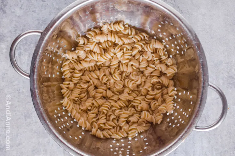Cooked spiral pasta in a strainer.