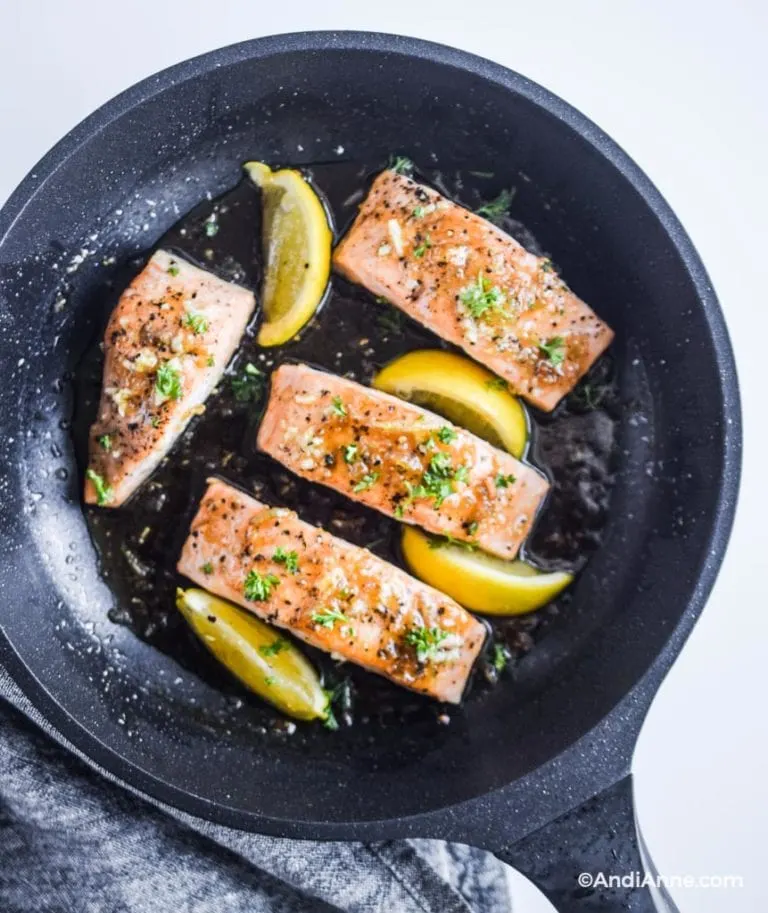 fully cooked honey glazed salmon fillets with lemon slices in frying pan