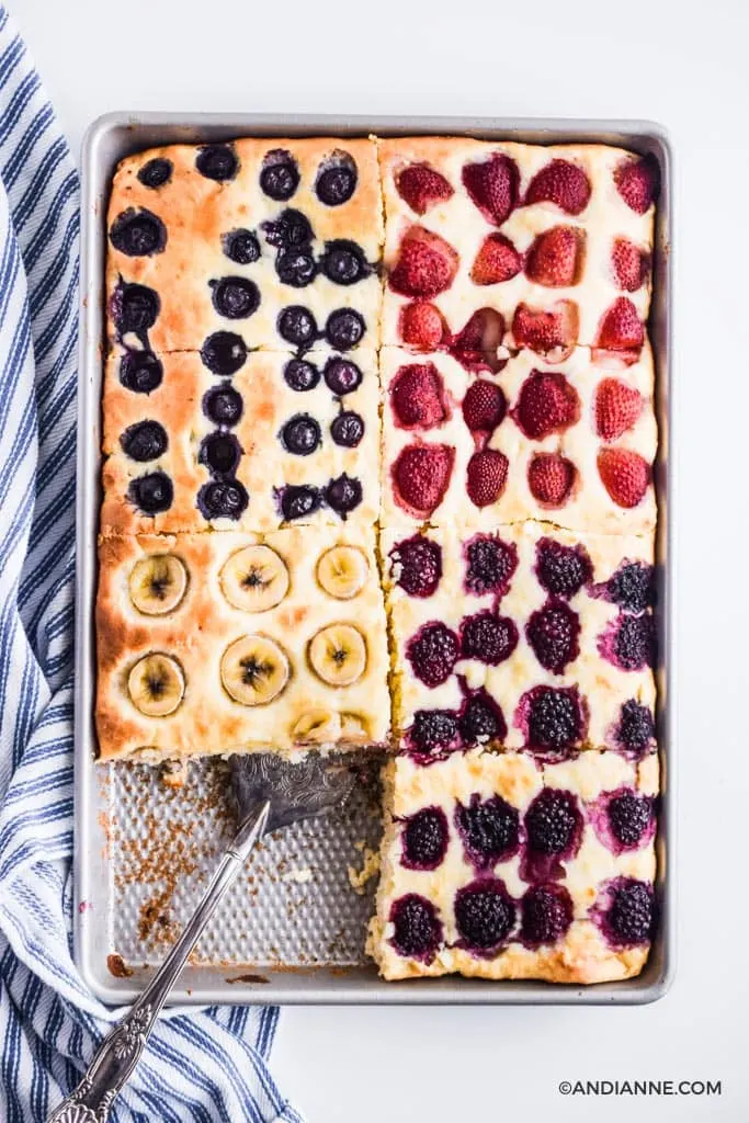 A sheet pan with baked pancake and sliced berries and bananas on top. 