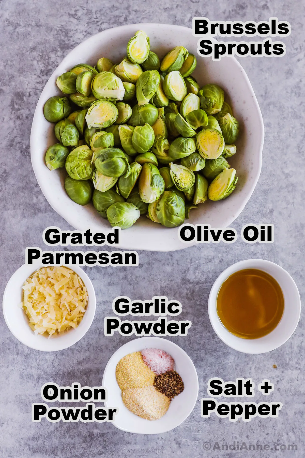 Recipe ingredients in bowls including sliced brussels sprouts, grated parmesan cheese, olive oil, garlic powder, onion powder, salt and pepper.