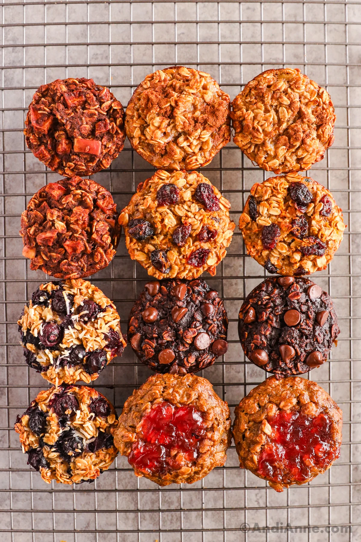 Close up of a dozen baked oatmeal cups with six different flavors. All on a rack to cool.