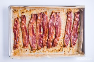 cooked bacon strips on a baking sheet