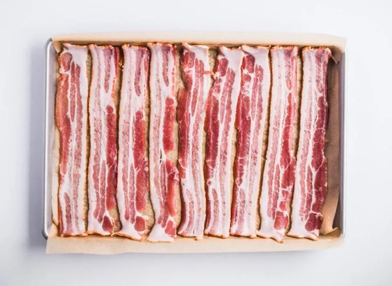 raw bacon in single layer on baking sheet