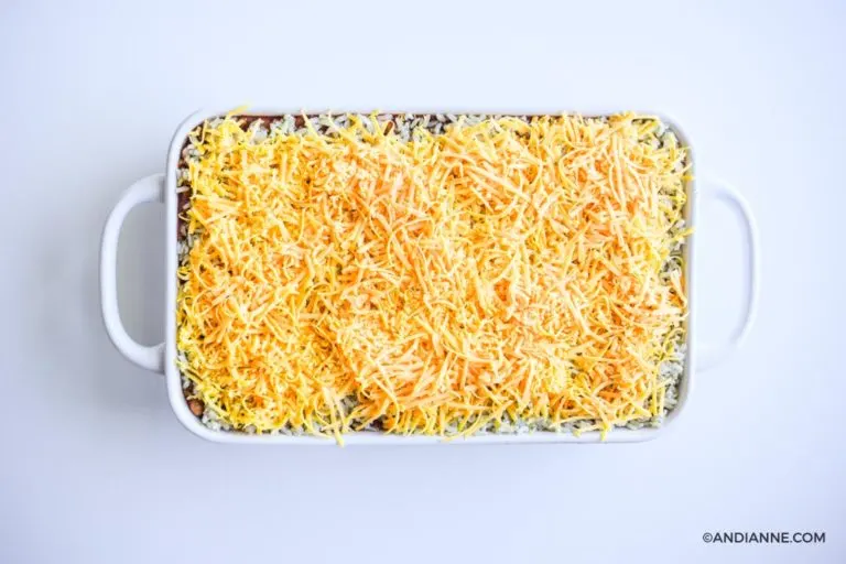 shredded cheddar cheese layer on top of white casserole dish