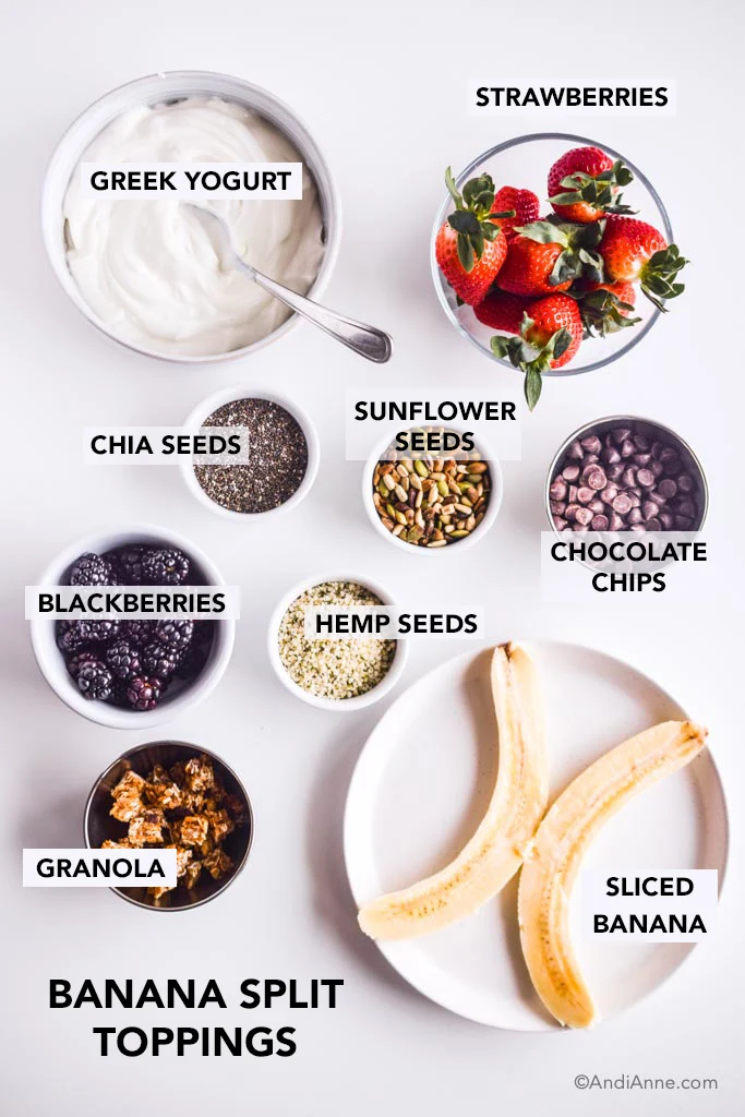 Ingredients in separate small bowls on white counter. Banana is sliced in half on a white plate.