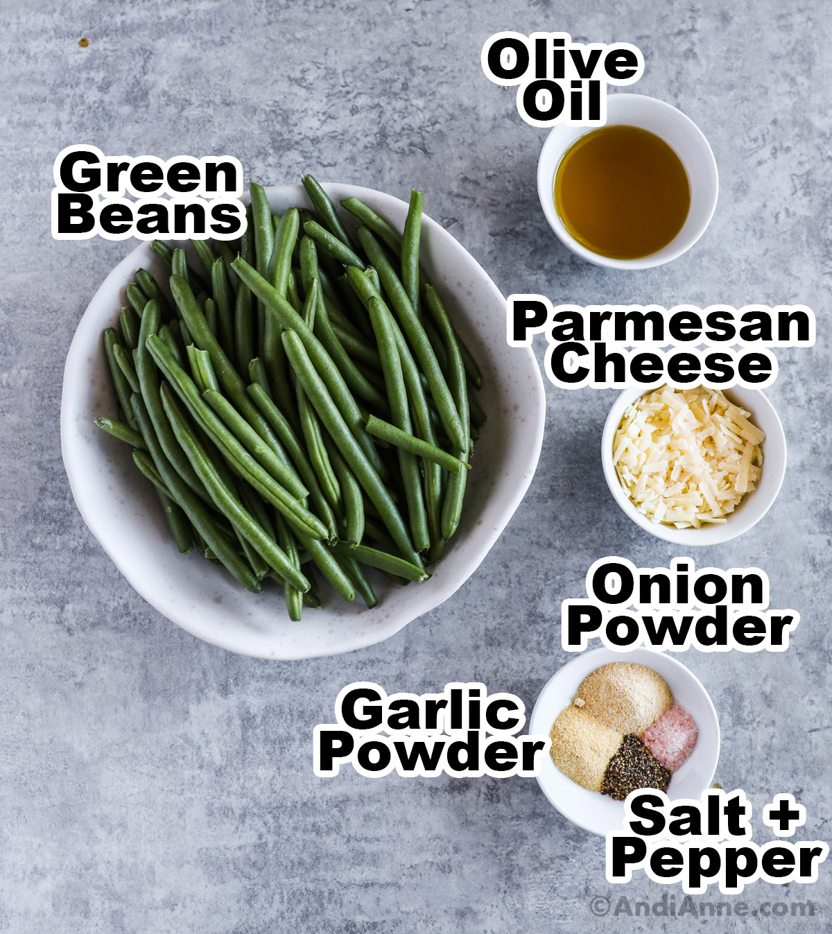 Recipe ingredients including bowl of fresh green beans, small bowls of olive oil, grated parmesan cheese, onion powder, garlic powder, salt and pepper.
