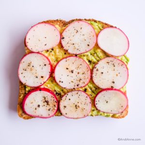 mashed avocado on toast with sliced radishes on top