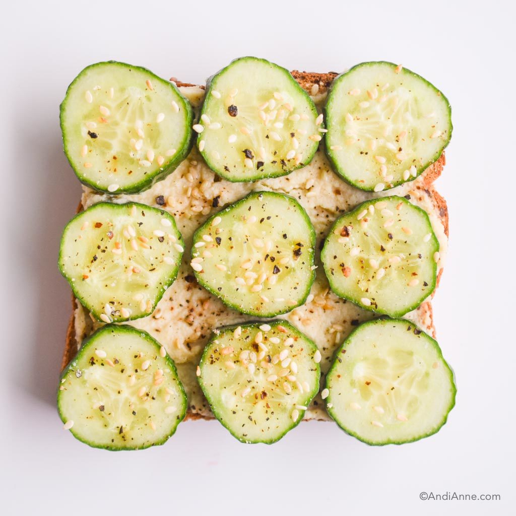 hummus on toast with sliced cucumber, and everything bagel seasoning