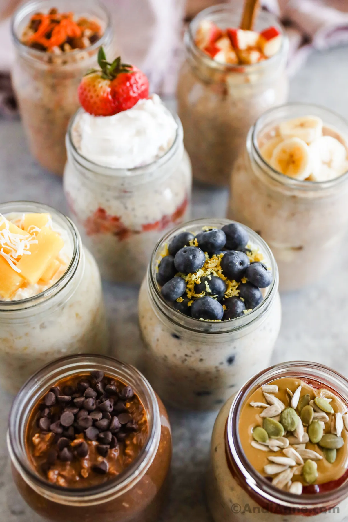 Various overnight oats recipes, all with different toppings made from different fruits, seeds, chocolate chips, and nut butter.