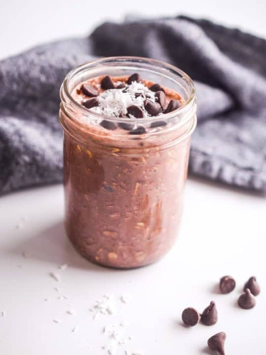 chocolate overnight oats with shredded coconut and dark chocolate chips on top