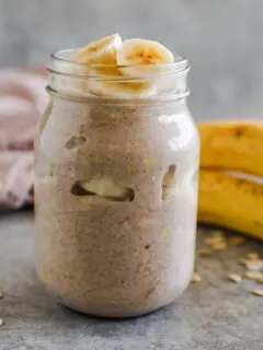 A mason jar with banana bread overnight oats and sliced of banana on top