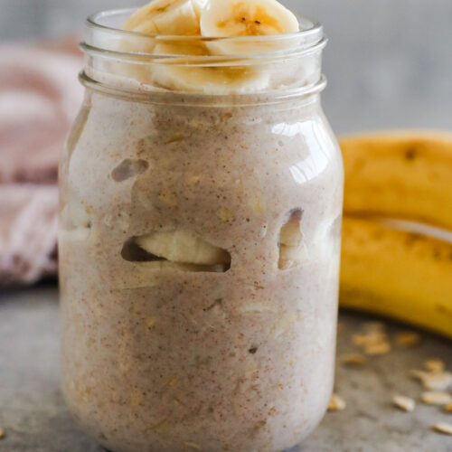 A mason jar with banana bread overnight oats and sliced of banana on top
