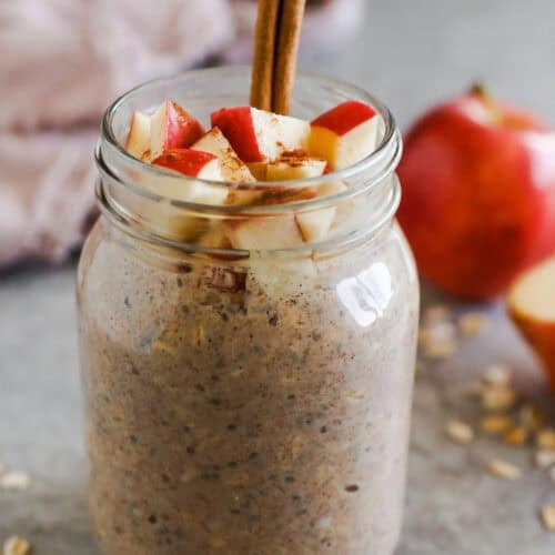 Mason jar with apple cinnamon overnight oats and a cinnamon stick