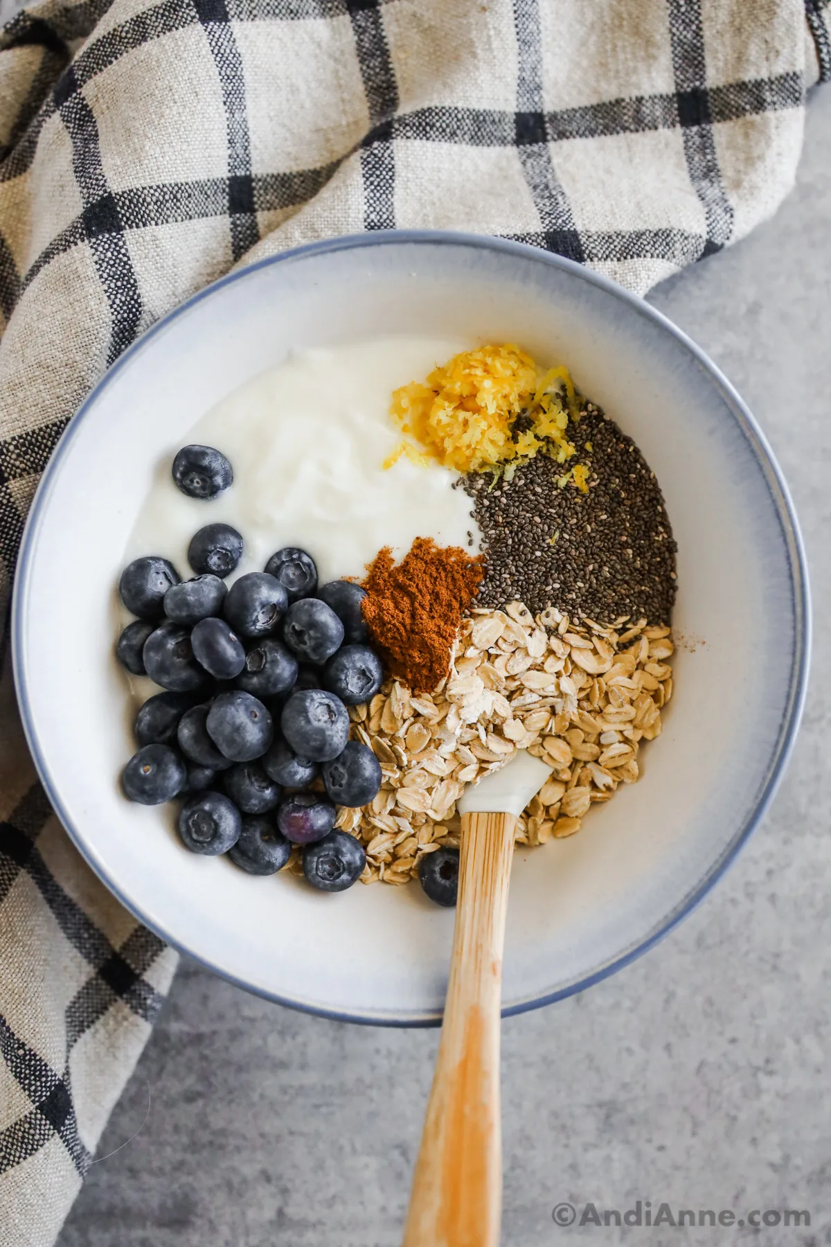 A bowl with rolled oats, blueberries, yogurt, cinnamon and lemon zest.