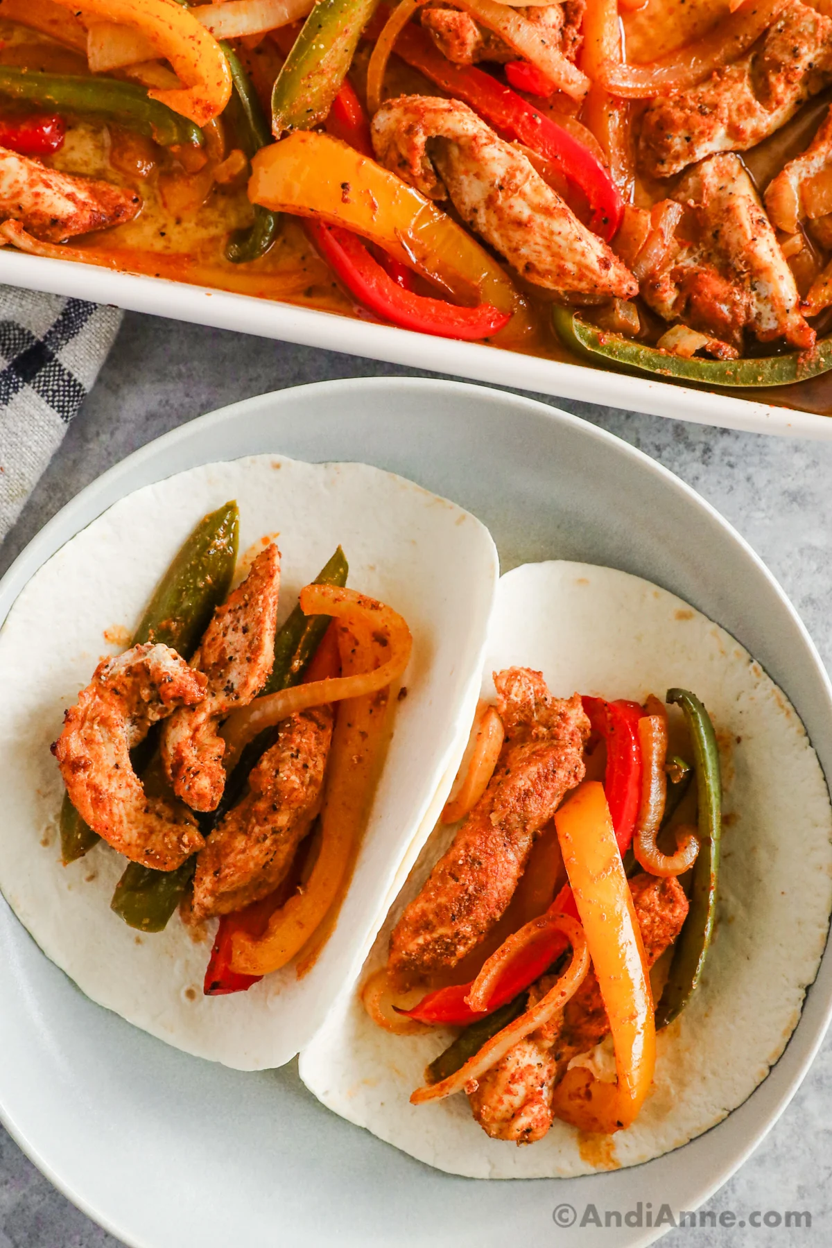 Soft tortillas with cooked chicken strips, bell pepper and onion inside them.