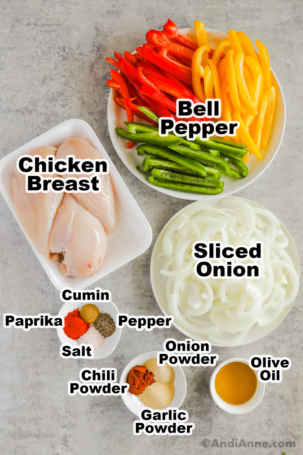 Recipe ingredients on plates and in bowls including sliced red, green and yellow bell pepper, 3 raw chicken breasts, sliced onion, various spices and olive oil.