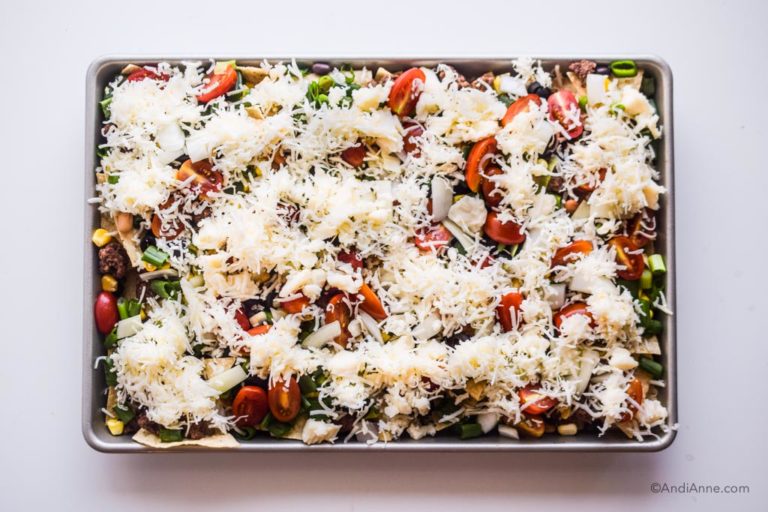 shredded mozzarella cheese sprinkled on top of the fresh veggies on the sheet pan