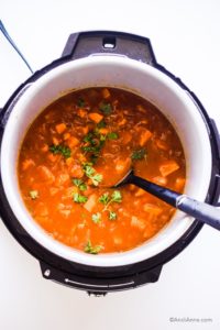 cooked sweet potato soup in an instant pot with black soup spoon