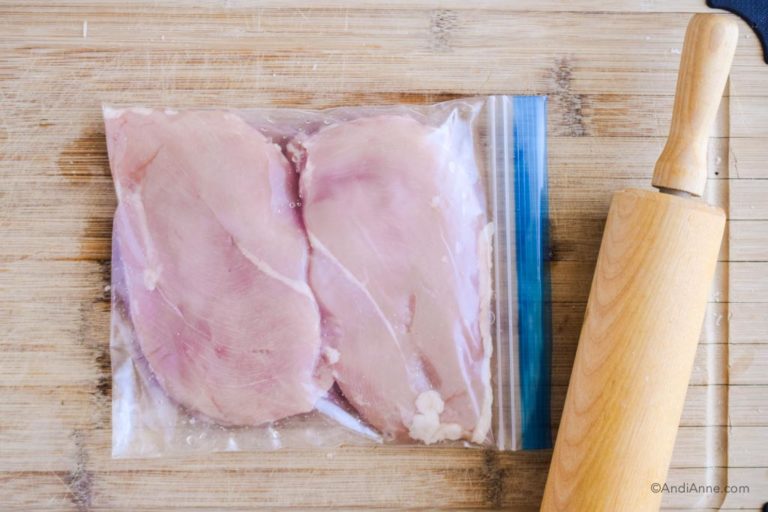 raw chicken in a bag with rolling pin beside it