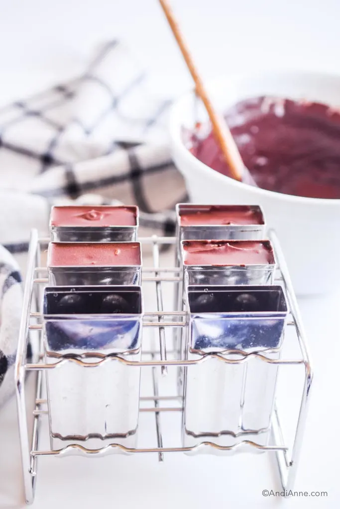 fudgesicle ingredients poured into steel popsicle moulds