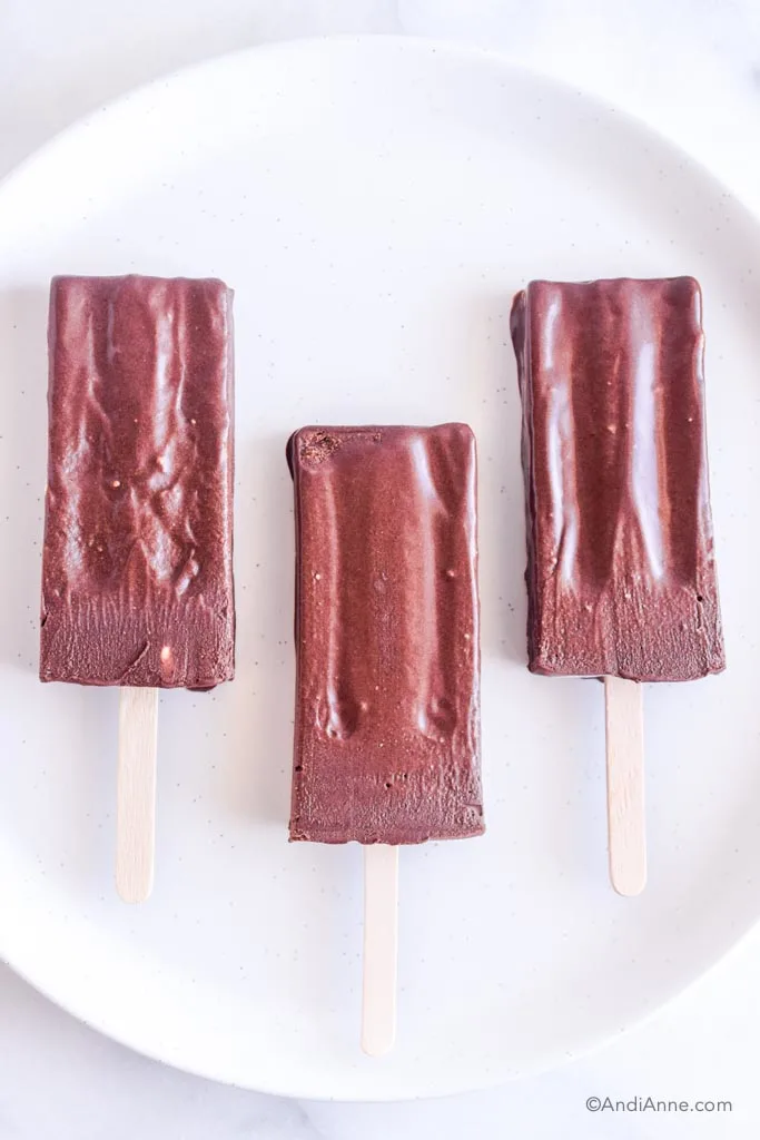 homemade fudgesicles melting on a white plate