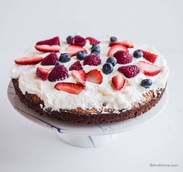 whipping cream and sliced berries on a single layer of cake