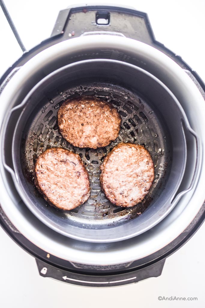 cooked burger patties in an air fryer